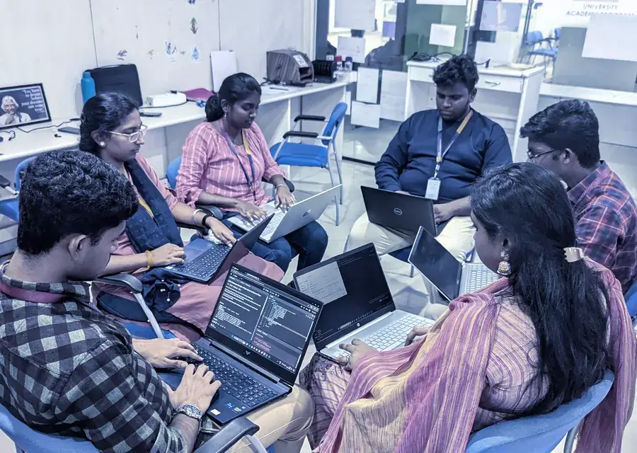 Interns coding together around a table